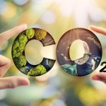 Mãos moldando as letras 'CO2' com elementos naturais, como musgo e água, representando o conceito de CO2 biogênico em um ambiente de sustentabilidade.